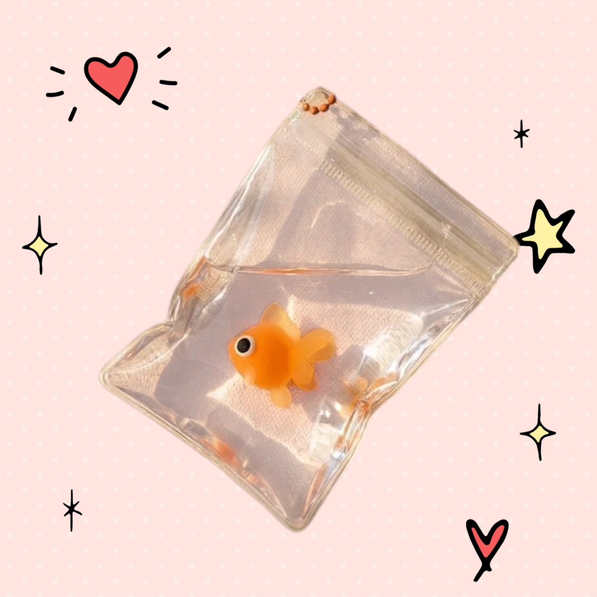 Foundry FitFit goldfish squishy toy in a clear water-filled bag keychain attached to a beige canvas tote bag