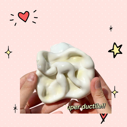 Foundry FitFit white glutinous sand fidget ball being stretched and shaped by hands for stress relief