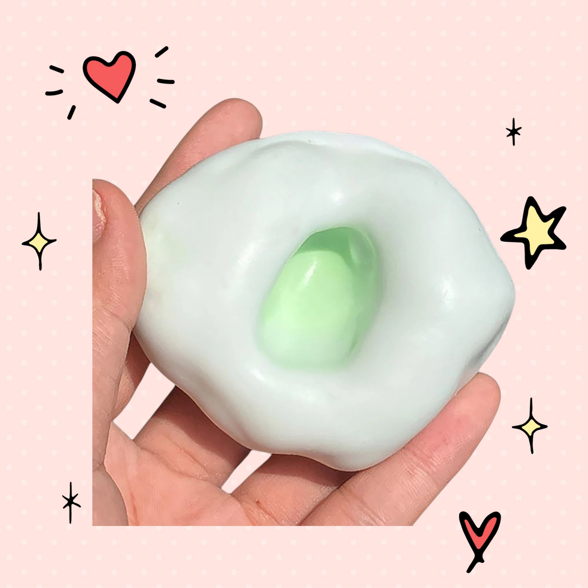 Foundry FitFit ultra-soft white and green sand-filled fidget ball being squeezed in a hand for stress relief