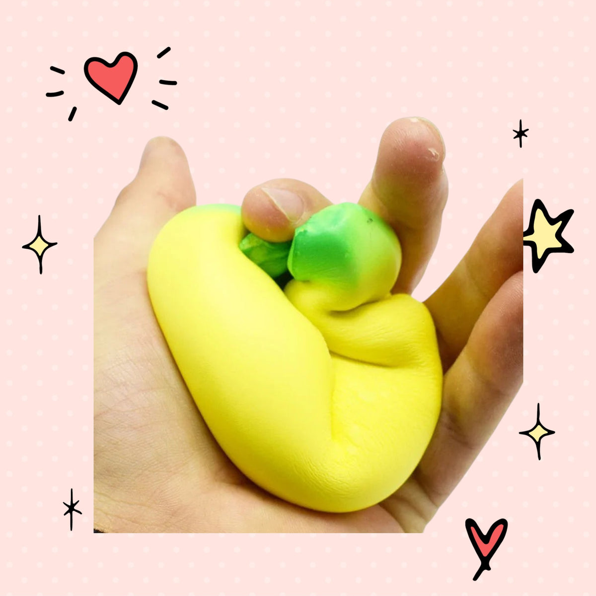 Foundry FitFit jumbo yellow banana slow-rise foam squishy toy being squeezed in a hand against a pink background