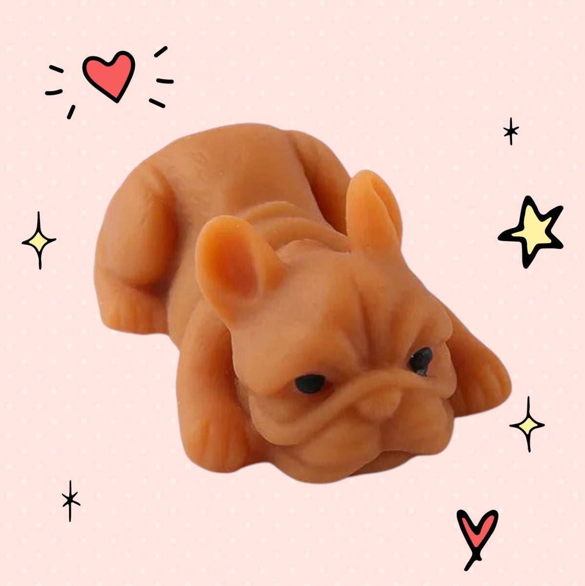 Foundry FitFit brown French bulldog squishy toy with a sleepy kawaii expression on a pink background with doodles.