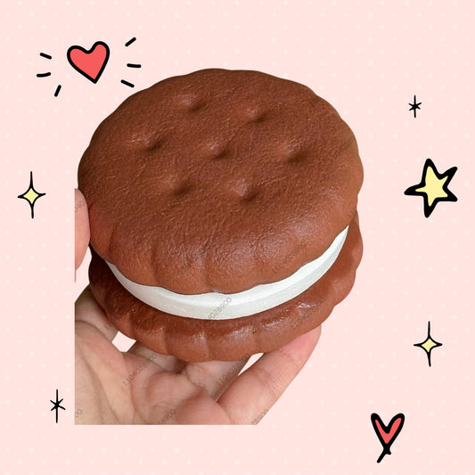 Foundry FitFit chocolate sandwich squishy with white cream filling held in hand, surrounded by pastel foam treats.