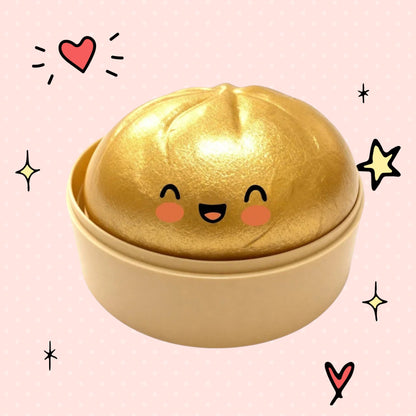 Foundry FitFit gold dumpling squishy toy with a cute smiling face in a small round container
