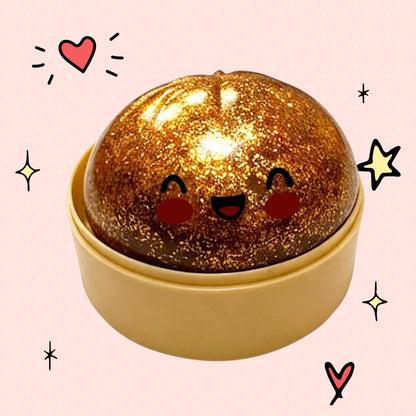 Foundry FitFit gold sequin dumpling squishy toy with a cute smiling face in a small round container