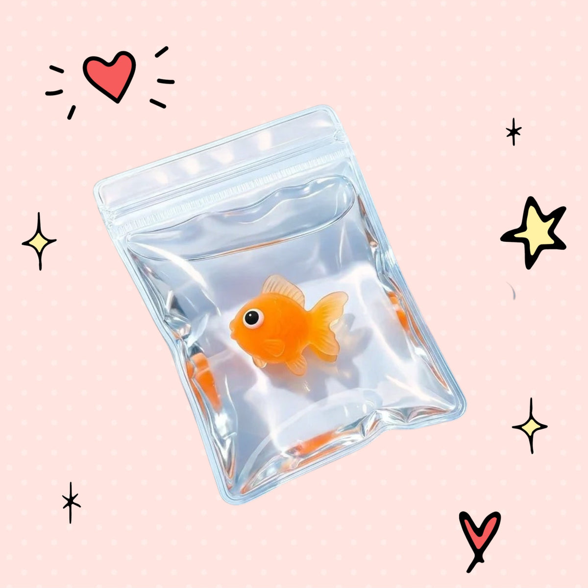 Foundry FitFit orange goldfish squishy toy inside a clear plastic bag on a pink background with doodle stars and hearts