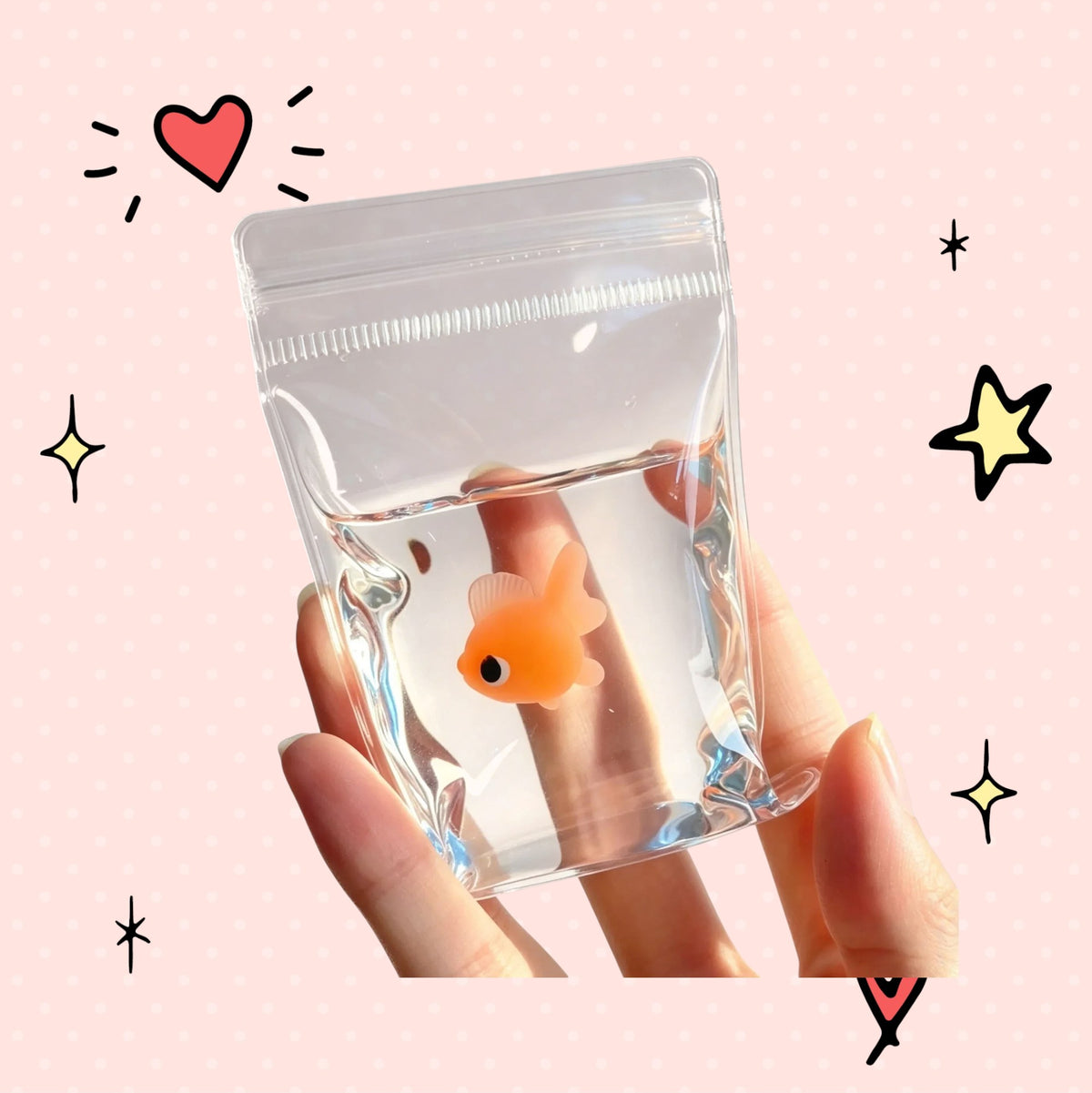 Foundry FitFit orange goldfish squishy toy inside a clear plastic bag held in a hand for stress relief.