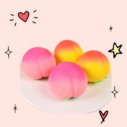 Foundry FitFit peach-shaped soft silicone squishy stress relief toys in pink and yellow on a white plate