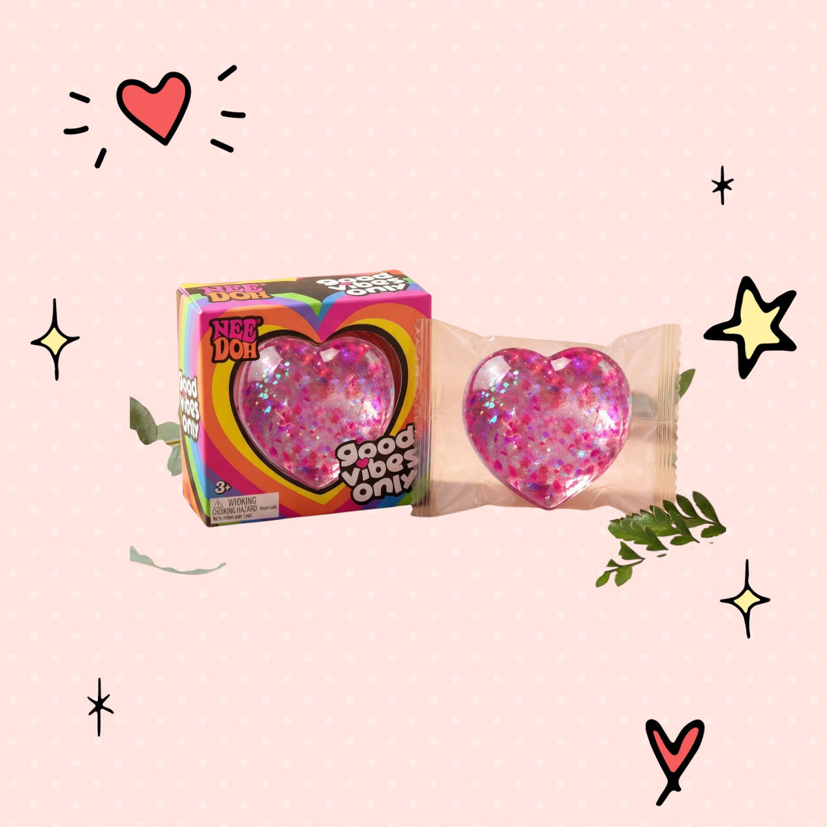 Foundry FitFit Caring Heart Squishy in pink with glitter, shown in packaging next to its colorful display box.