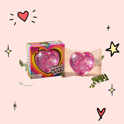 Foundry FitFit Caring Heart Squishy in pink with glitter, shown in packaging next to its colorful display box.