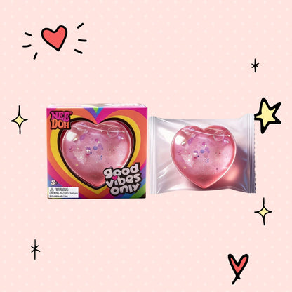 Foundry FitFit Caring Heart Squishy in pink with glitter, shown in packaging and as a loose stress-relief toy.