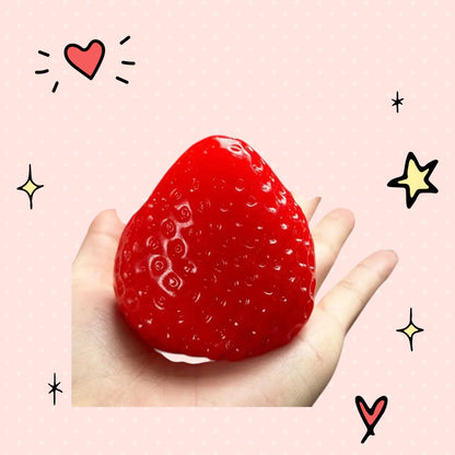 Foundry FitFit red strawberry squishy stress relief toy held in a palm, featuring a soft and textured fruit design.