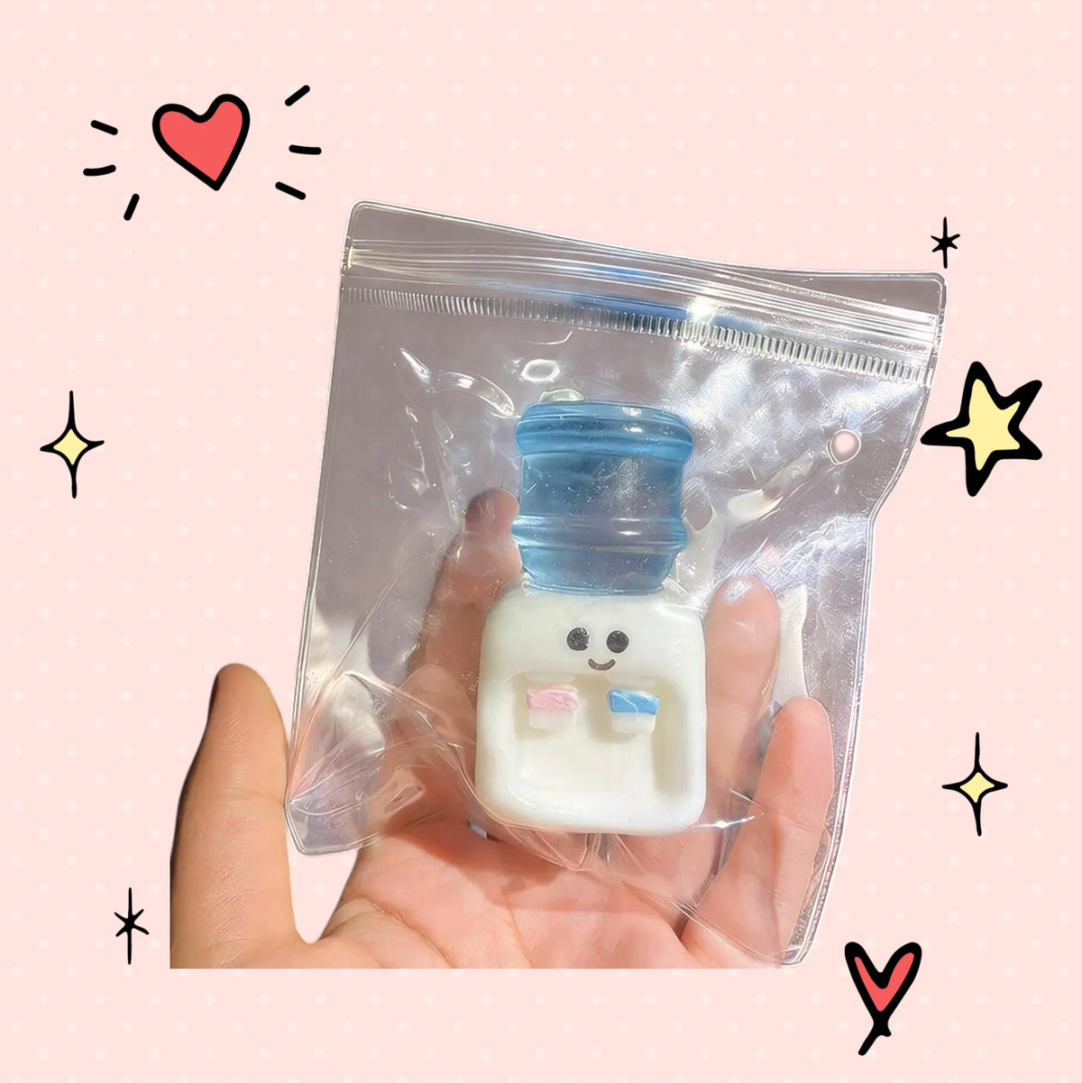 Foundry FitFit water cooler squishy fidget toy in a clear plastic bag held in a hand against a pink dotted background