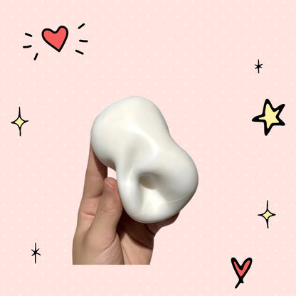Foundry FitFit white squishy soap ball for stress relief held in a hand against a pink polka dot background
