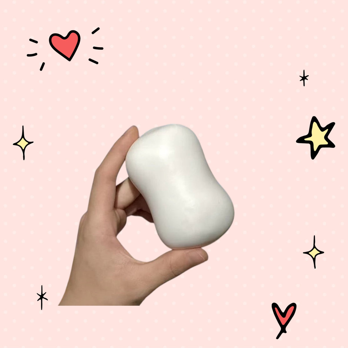 Foundry FitFit white squishy soap ball held in hand for stress relief and fidgeting on a pink background