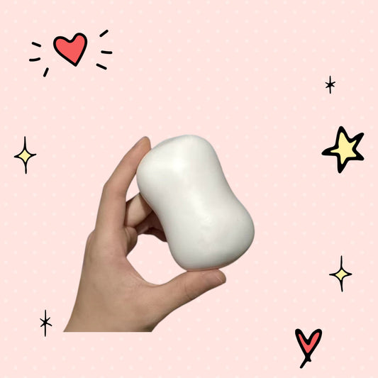 Foundry FitFit white squishy soap ball held in hand for stress relief and fidgeting on a pink background
